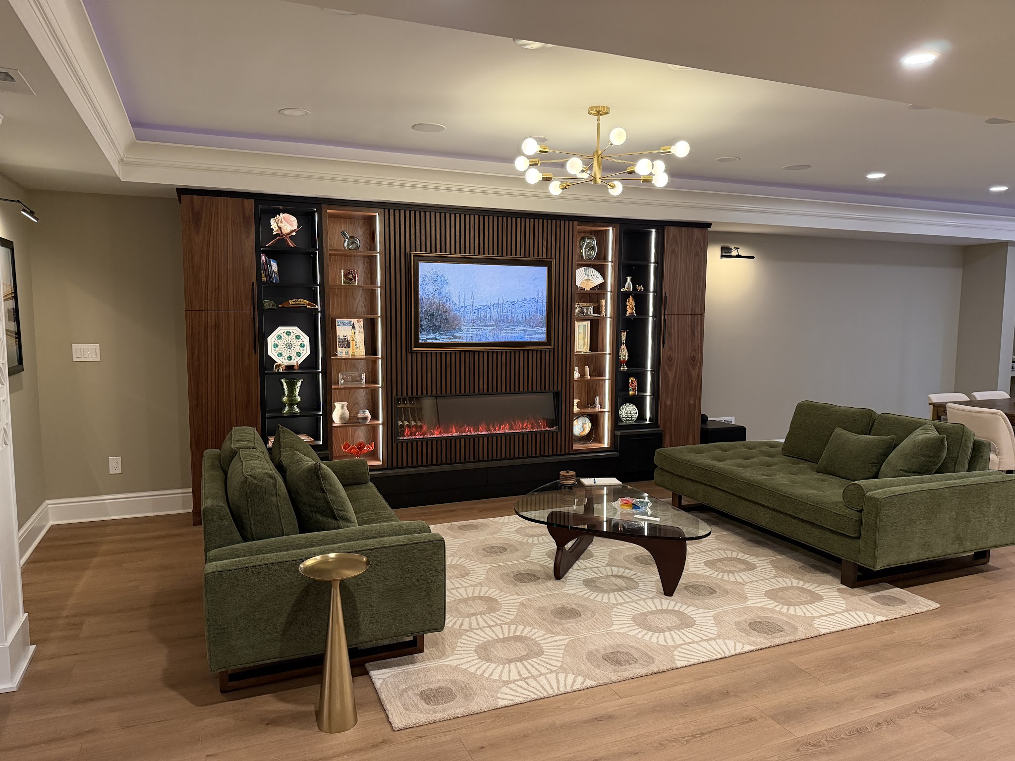 Basement Lounge & Media Wall — A finished lounge with a linear fireplace, built-in media wall, and lighting.