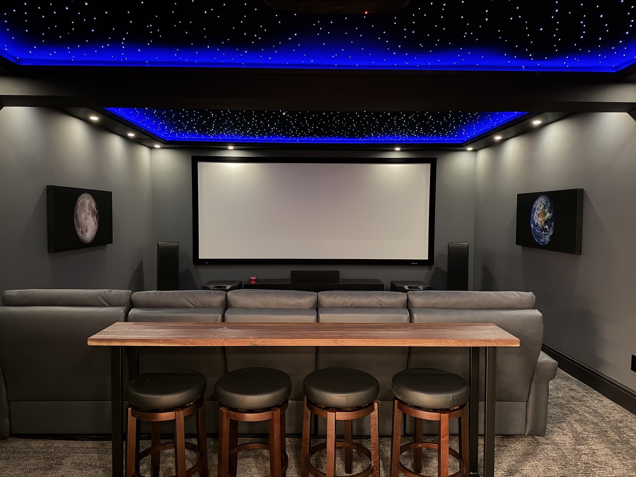 Home Theater — A dedicated theater with a starlight ceiling, tiered seating, and a bar rail.